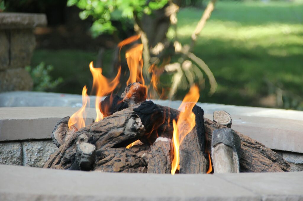 Getting the fire ready with wooden logs in the fire pit for a fun summer gathering.