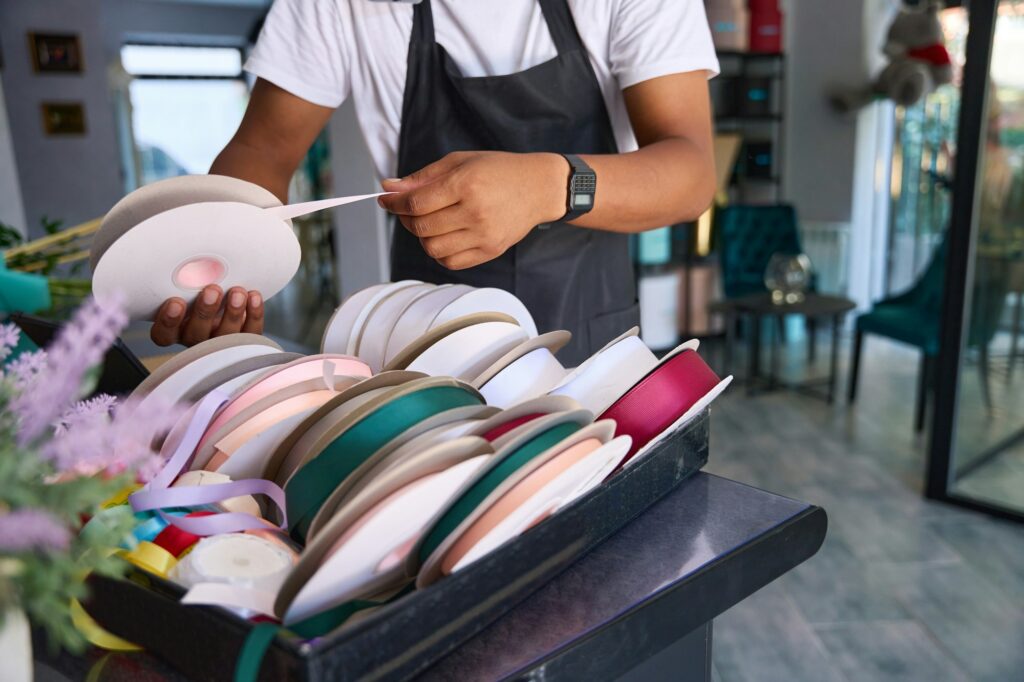 Multiracial man in an apron chooses a ribbon