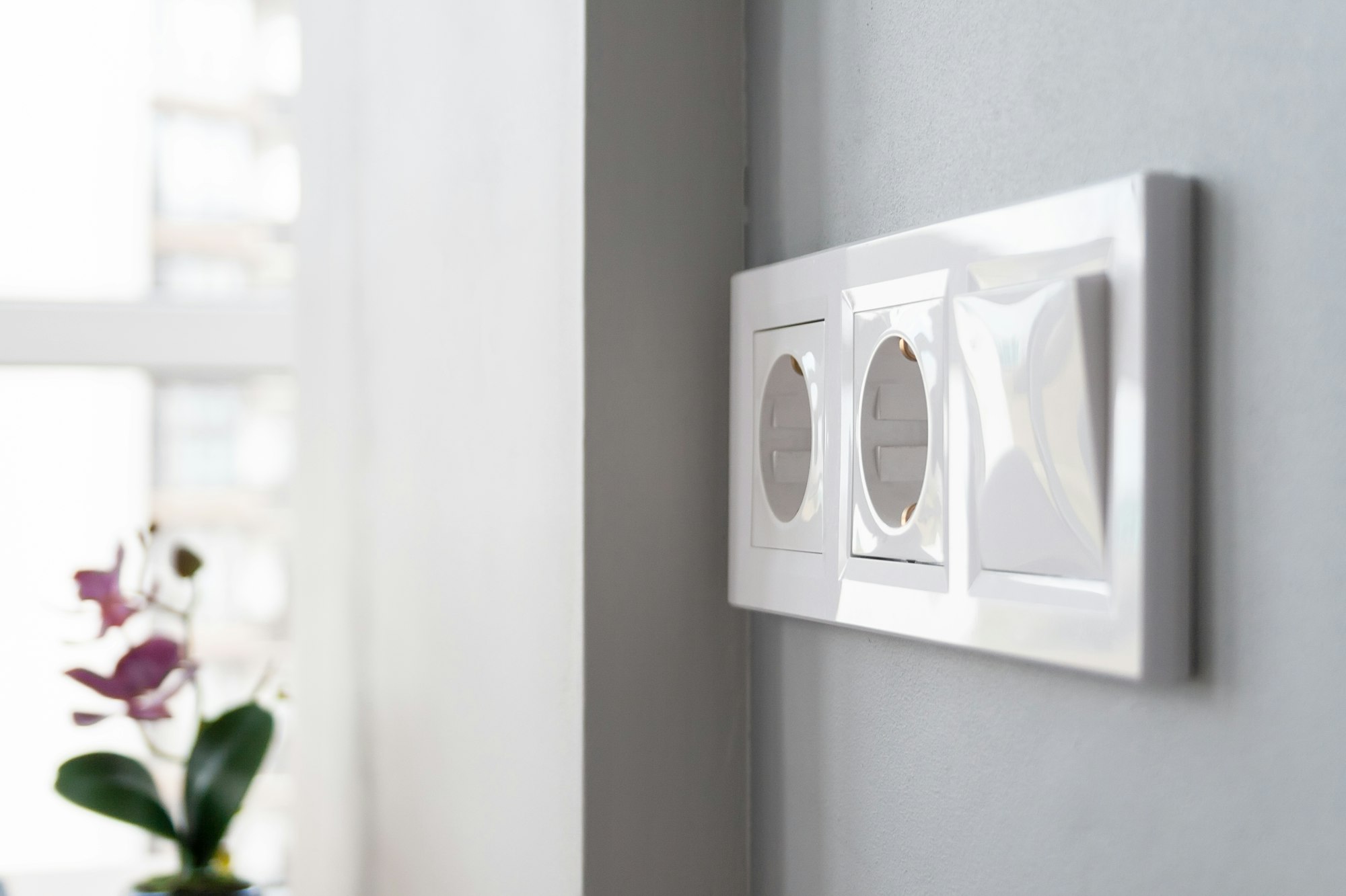 Electrical outlets and switch on gray wall in light modern kitchen