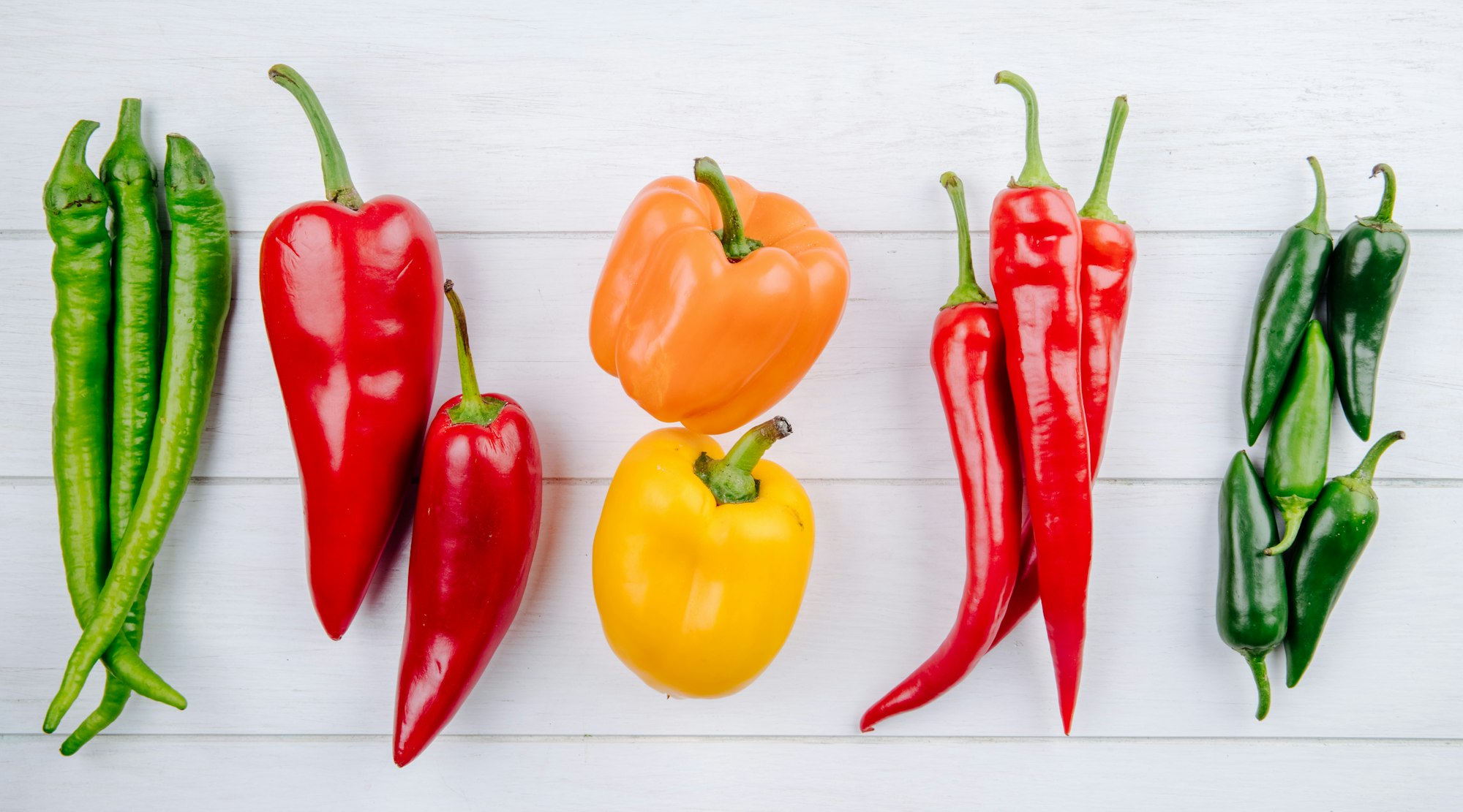 top view of various types of peppers bell peppers with green and red hot chili peppers